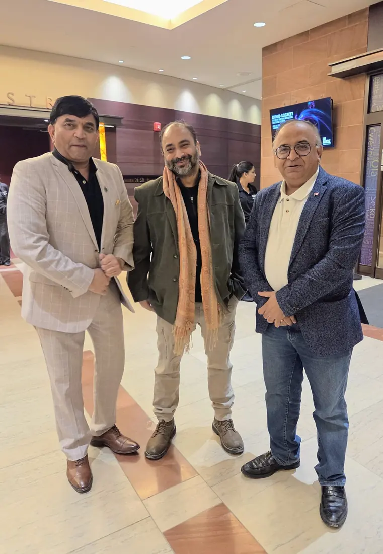 Husain with community members at a theatre lobby