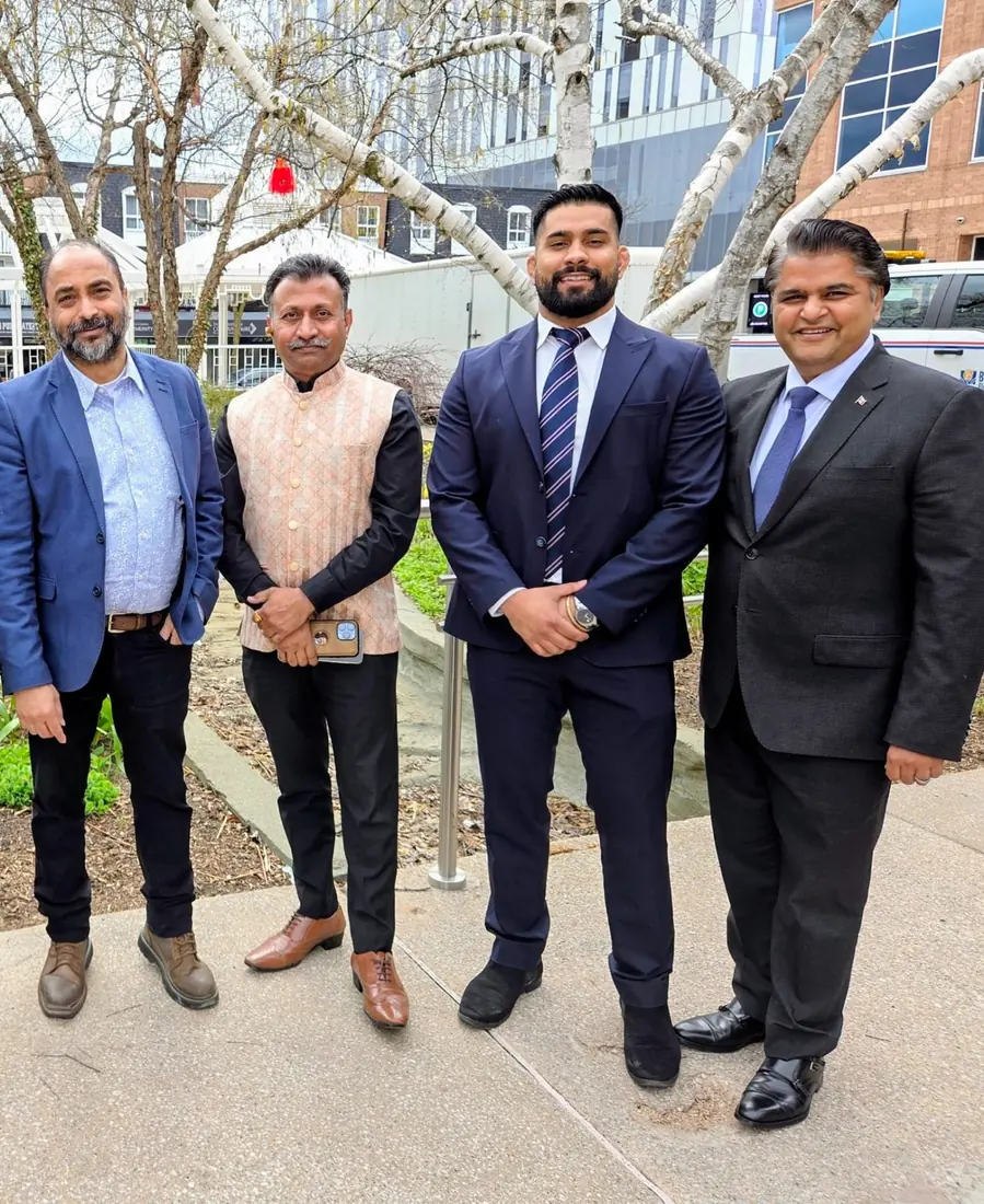 Husain with community leaders outside a local building