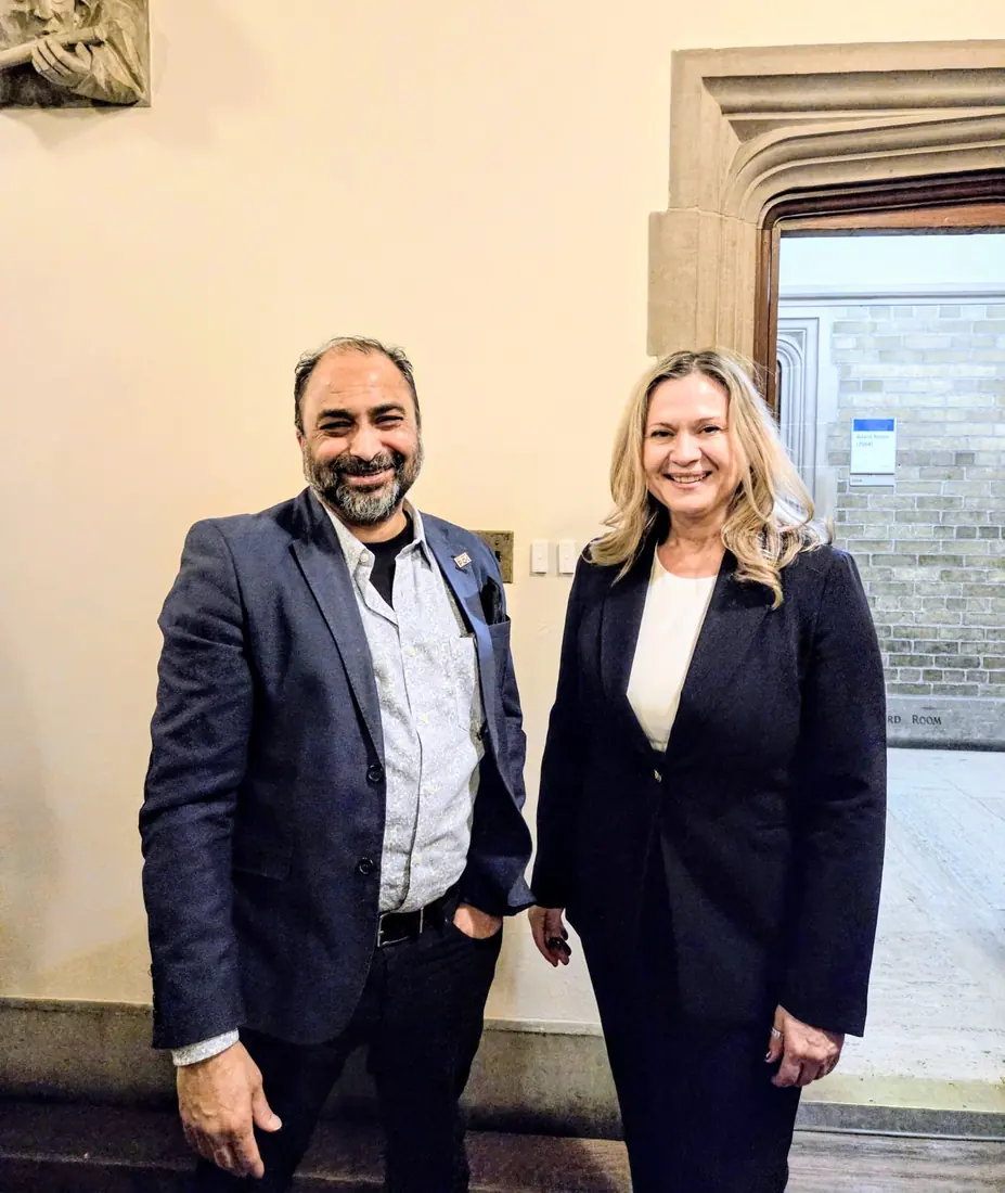 Husain with a colleague at a board room